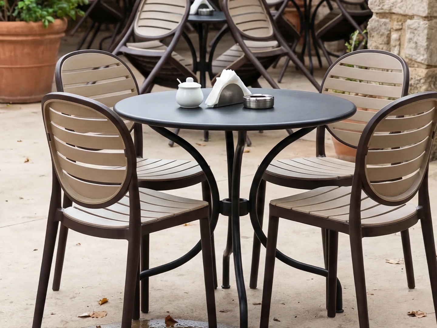 Mesa com cadeiras de resina bicolores em ambiente externo